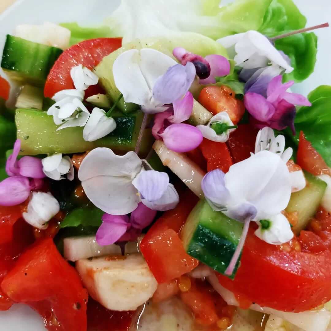 Salade printanière composée de légumes et de fleurs sauvages